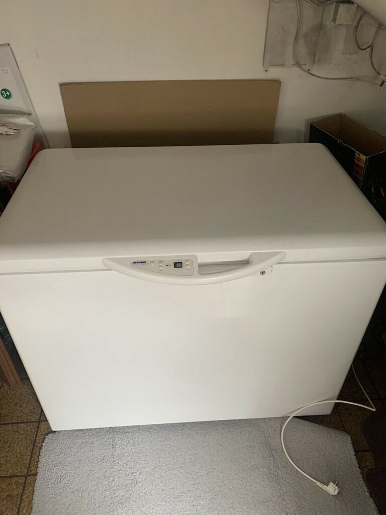 A white chest freezer standing indoors